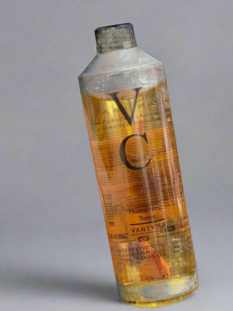 Vanekar bottle with orange liquid on a gray background